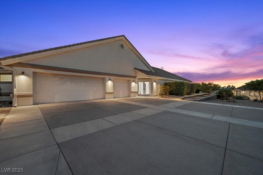 640 Quail Covey Road Henderson, NV 89002 - Photo 74 of 75 View of main house garage featuring stucco siding, concrete driveway