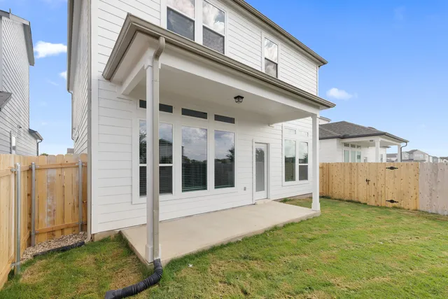 a view of a white house with large windows and a small yard