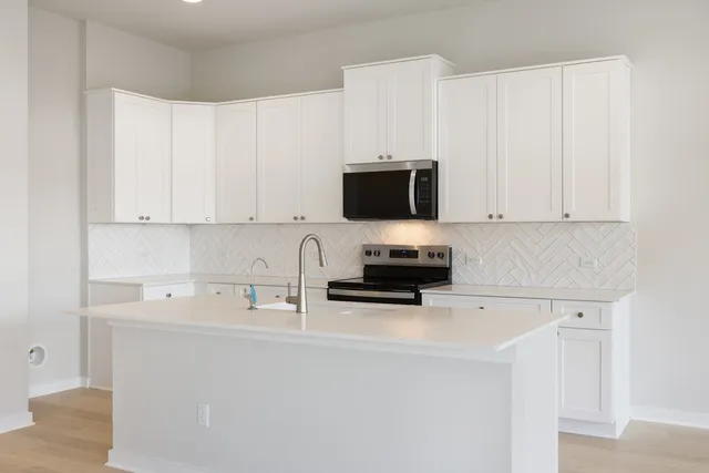 a kitchen with a sink appliances and cabinets