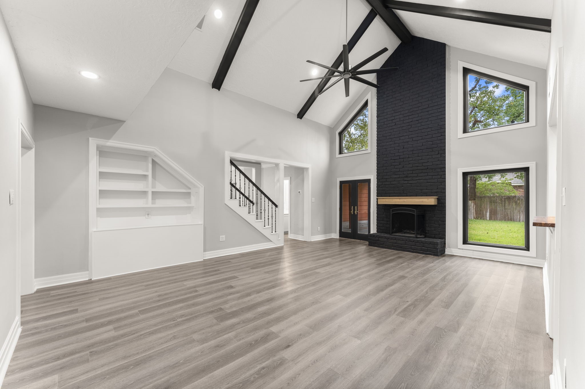 6415 Singing Creek Lane Spring, TX 77379 - Photo 15 of 29 an empty room with wooden floor fireplace and windows