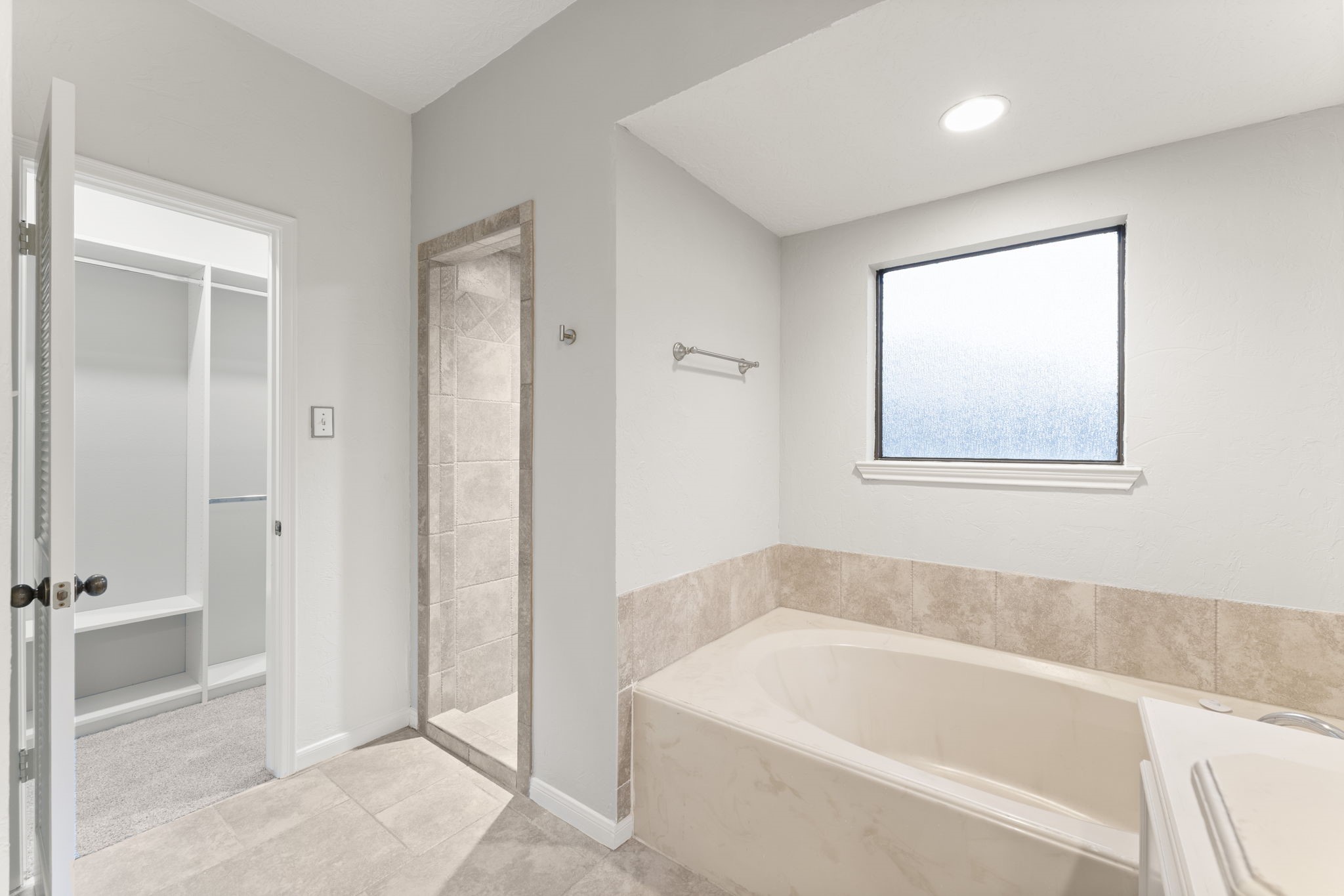 6415 Singing Creek Lane Spring, TX 77379 - Photo 24 of 34 Separate soaking tub and shower in the downstairs primary ensuite.