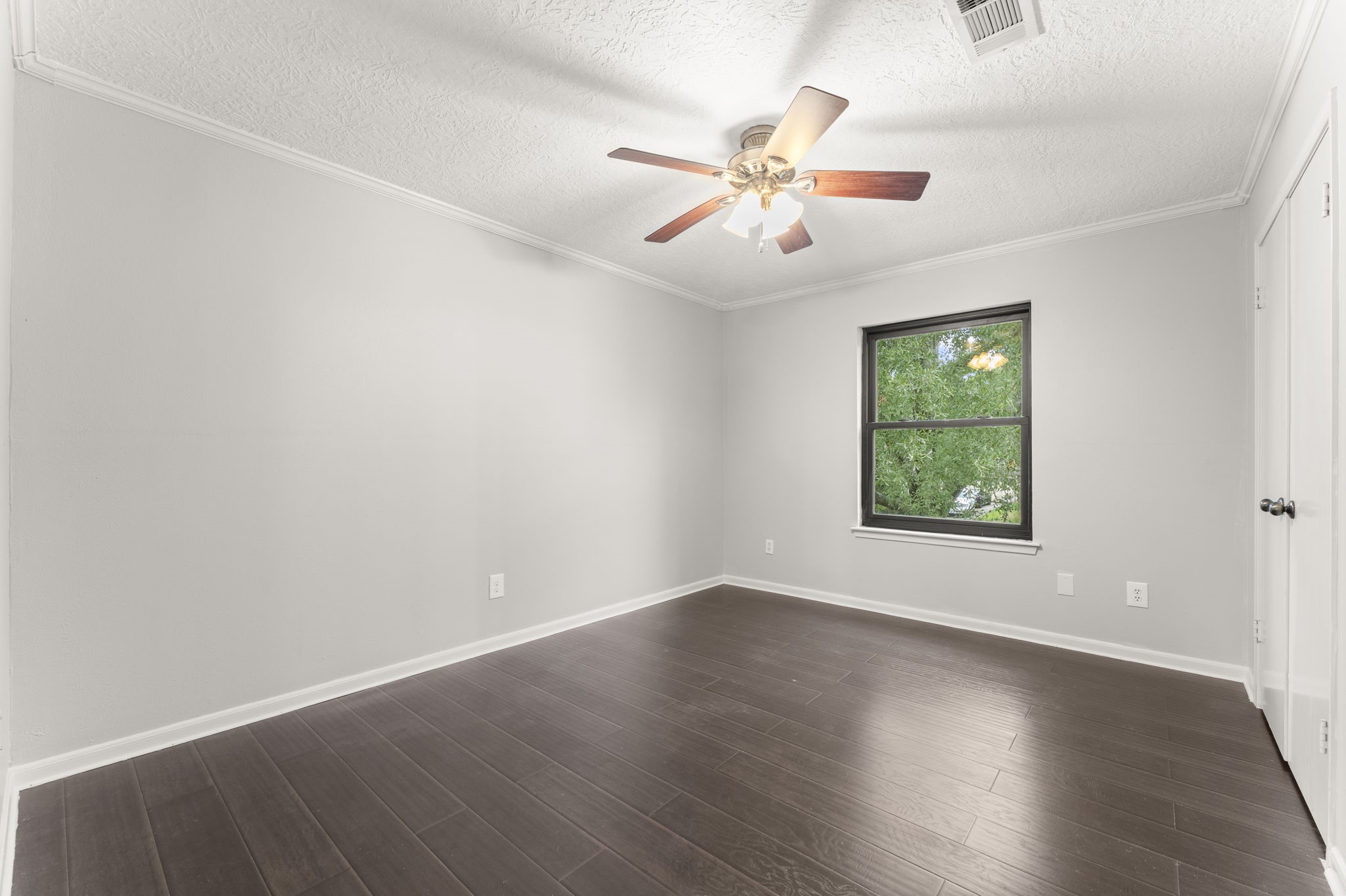 6415 Singing Creek Lane Spring, TX 77379 - Photo 25 of 29 an empty room with wooden floor chandelier fan and windows