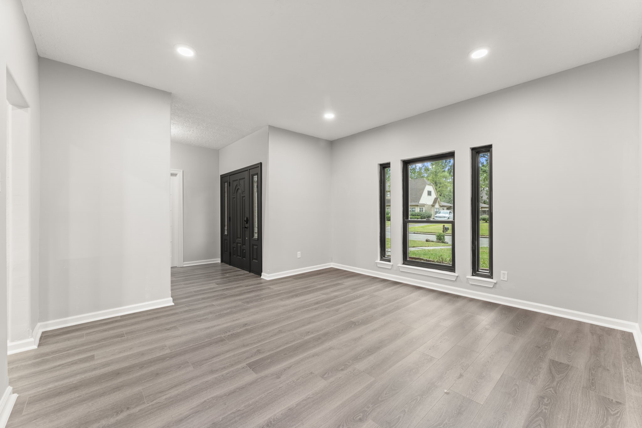 6415 Singing Creek Lane Spring, TX 77379 - Photo 6 of 29 a view of an empty room with wooden floor and windows