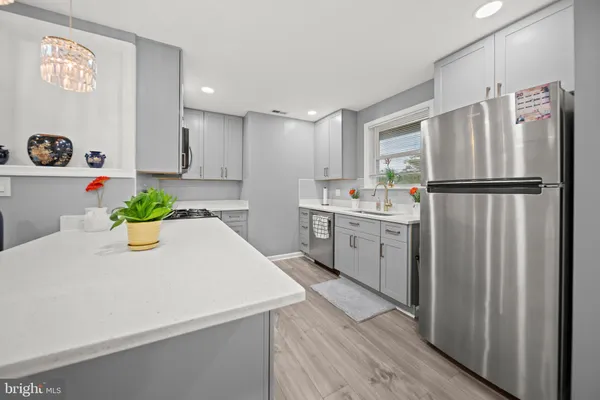 a white kitchen with a refrigerator a sink and white cabinets