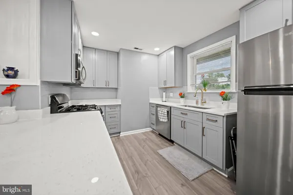 a kitchen with a refrigerator a sink and a stove top oven