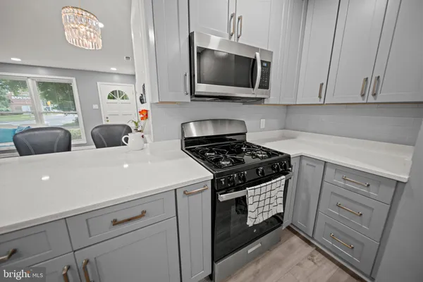 a kitchen with stainless steel appliances granite countertop a stove a microwave and cabinets