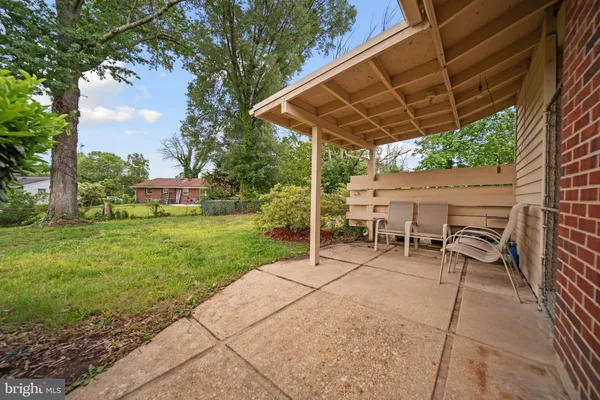 a view of patio with table and chairs under an umbrella with a barbeque