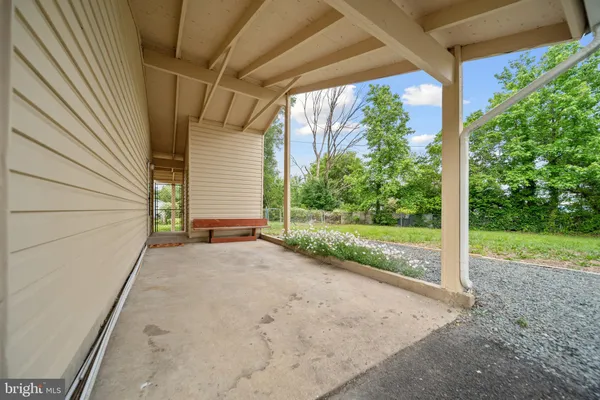 a view of a backyard with porch and garden