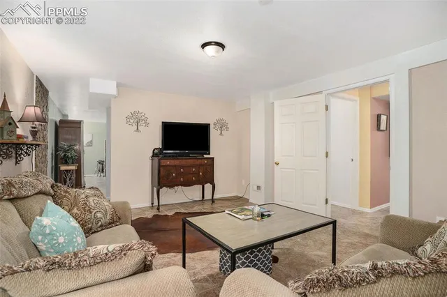 a living room with furniture a fireplace and a large window