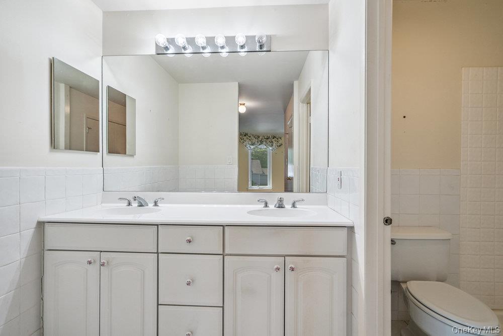 914 Fenway Road St. James, NY 11780 - Photo 22 of 35 a bathroom with a double vanity sink toilet and a mirror