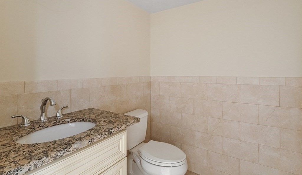 25 Viking Road Saugus, MA 01906 - Photo 21 of 33 a bathroom with a granite countertop sink a toilet and mirror