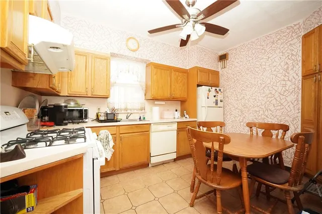 a kitchen with a dining table chairs and white appliances