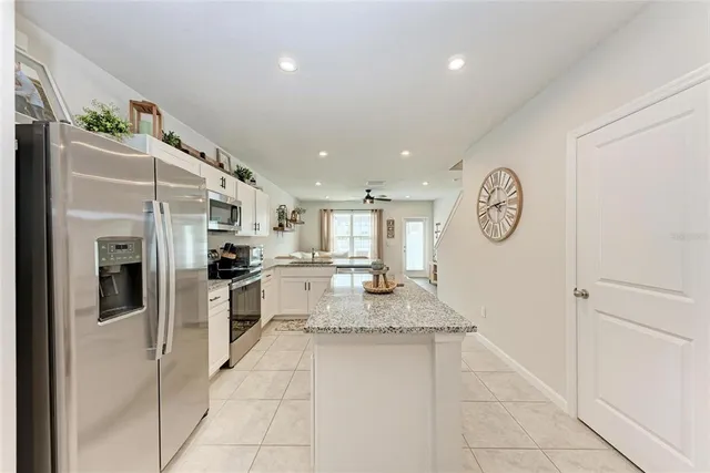 a kitchen with stainless steel appliances granite countertop a refrigerator and a stove top oven