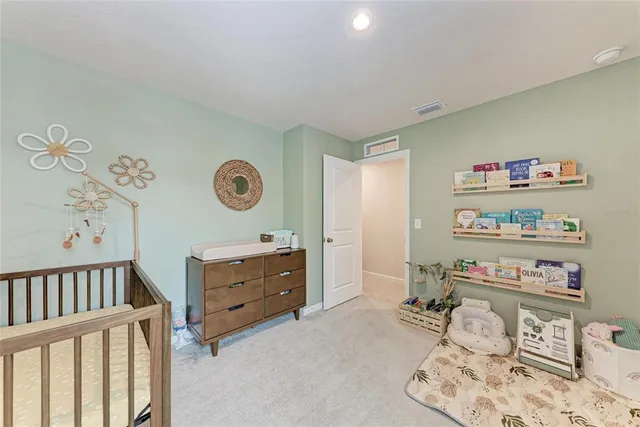 a bedroom with a bed flat screen tv and windows