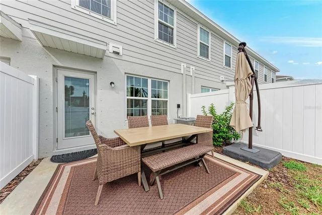 a view of a backyard with table and chairs under an umbrella