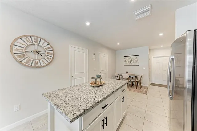 an open kitchen with granite countertop a table and chairs in it