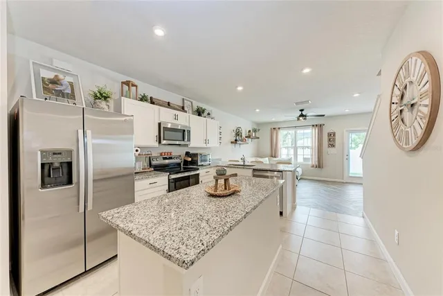 a kitchen with stainless steel appliances granite countertop a refrigerator and a stove top oven