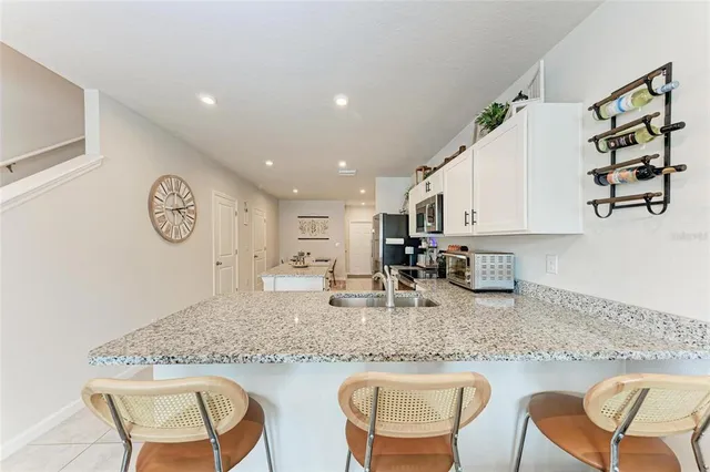 a kitchen with granite countertop kitchen island stainless steel appliances a sink and cabinets