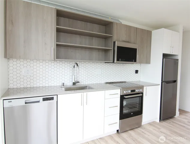 a kitchen with stainless steel appliances a refrigerator and a stove top oven