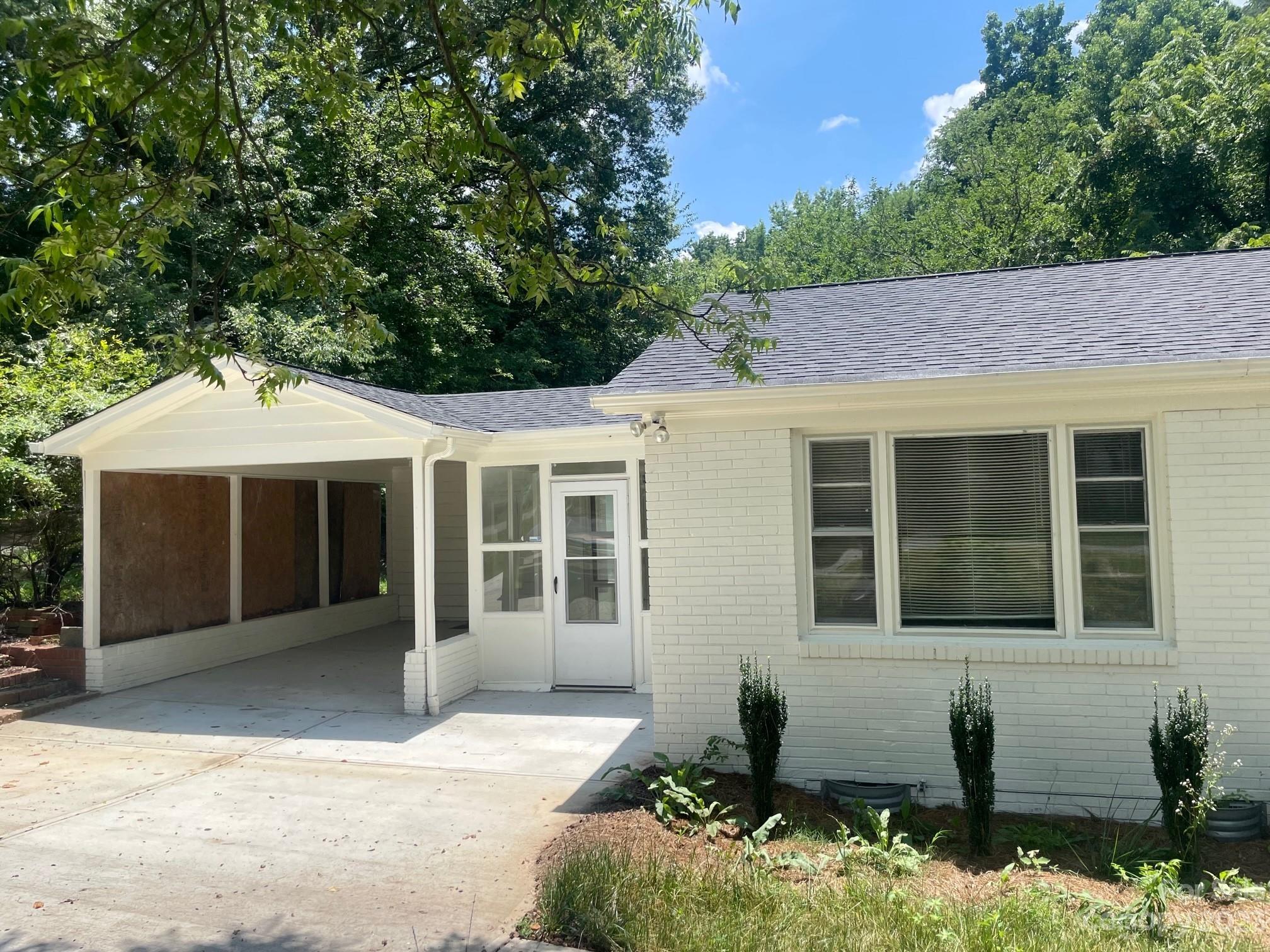 8710 Moody Road Charlotte, NC 28215 - Photo 3 of 14 a front view of a house with a yard and potted plants