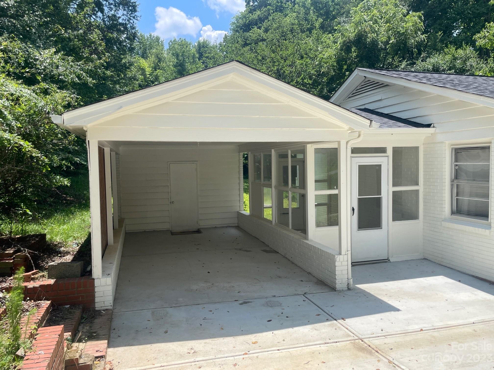 8710 Moody Road Charlotte, NC 28215 - Photo 4 of 14 a view of a white house with a large windows and potted plants