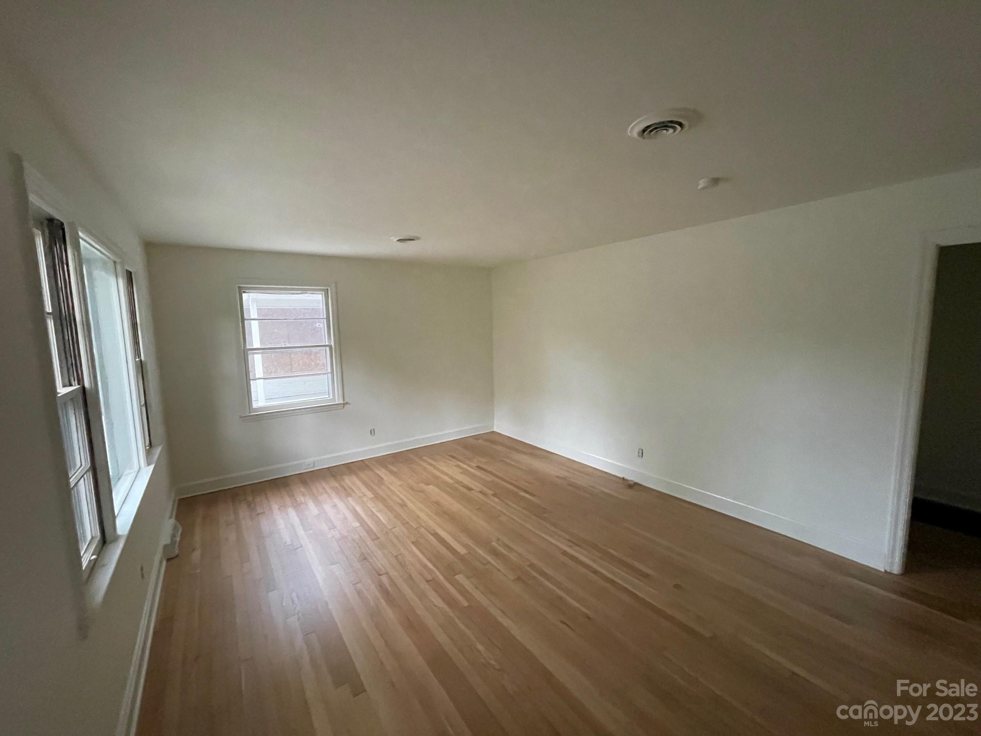 8710 Moody Road Charlotte, NC 28215 - Photo 9 of 14 an empty room with wooden floor and windows