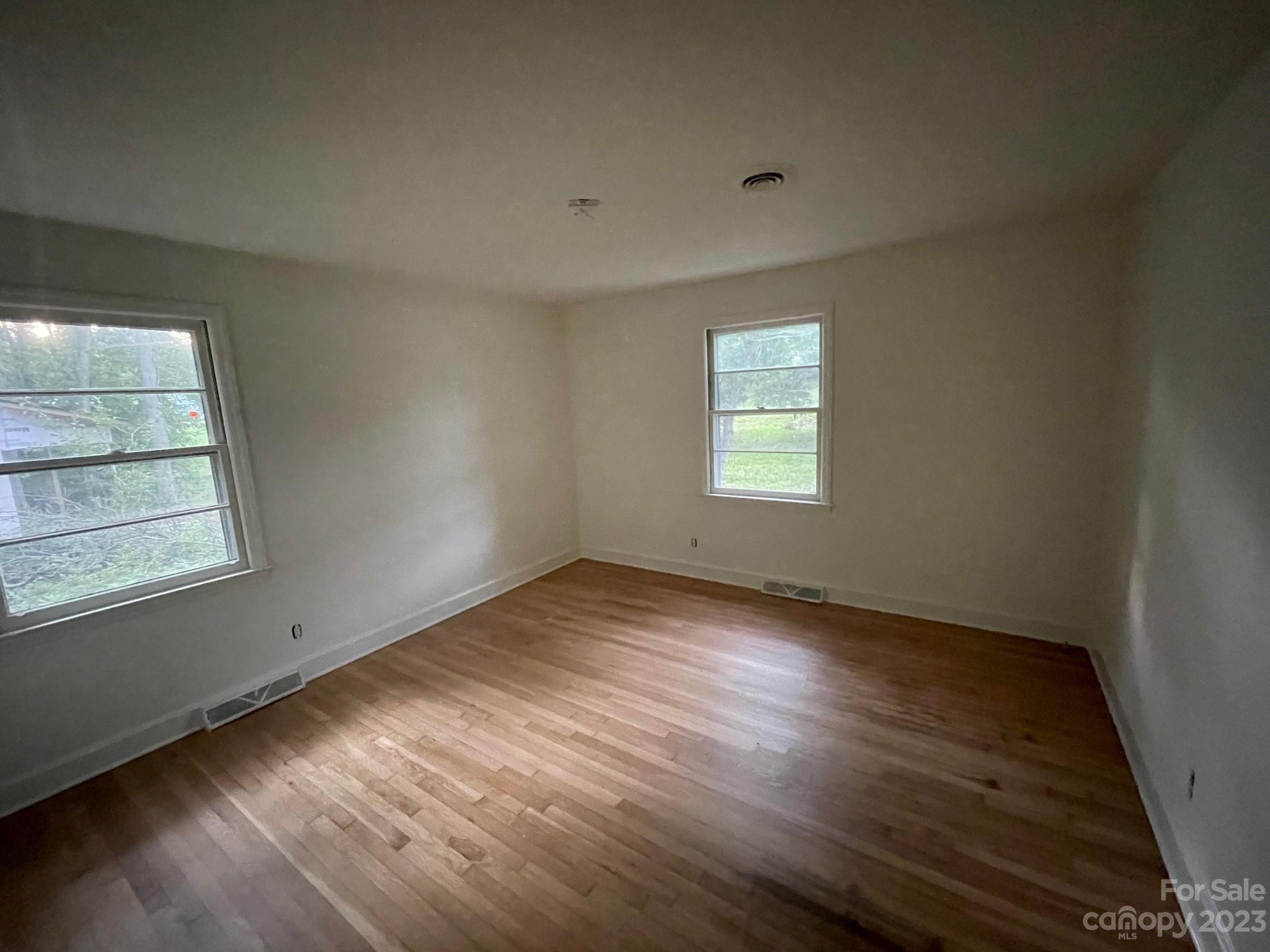 8710 Moody Road Charlotte, NC 28215 - Photo 10 of 14 an empty room with wooden floor and windows