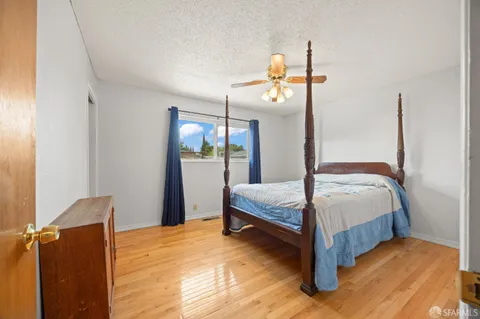 a bedroom with a bed a mirror and lamp