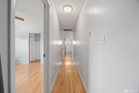 a view of a hallway with wooden floor