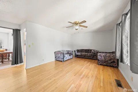 a view of a room with wooden floor and chandelier