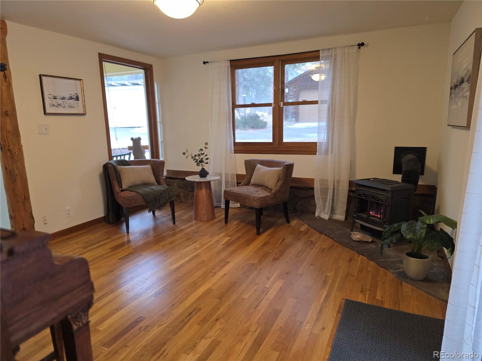 8830 South Blue Creek Road Evergreen, CO 80439 - Photo 17 of 39 a living room with furniture a piano and a window