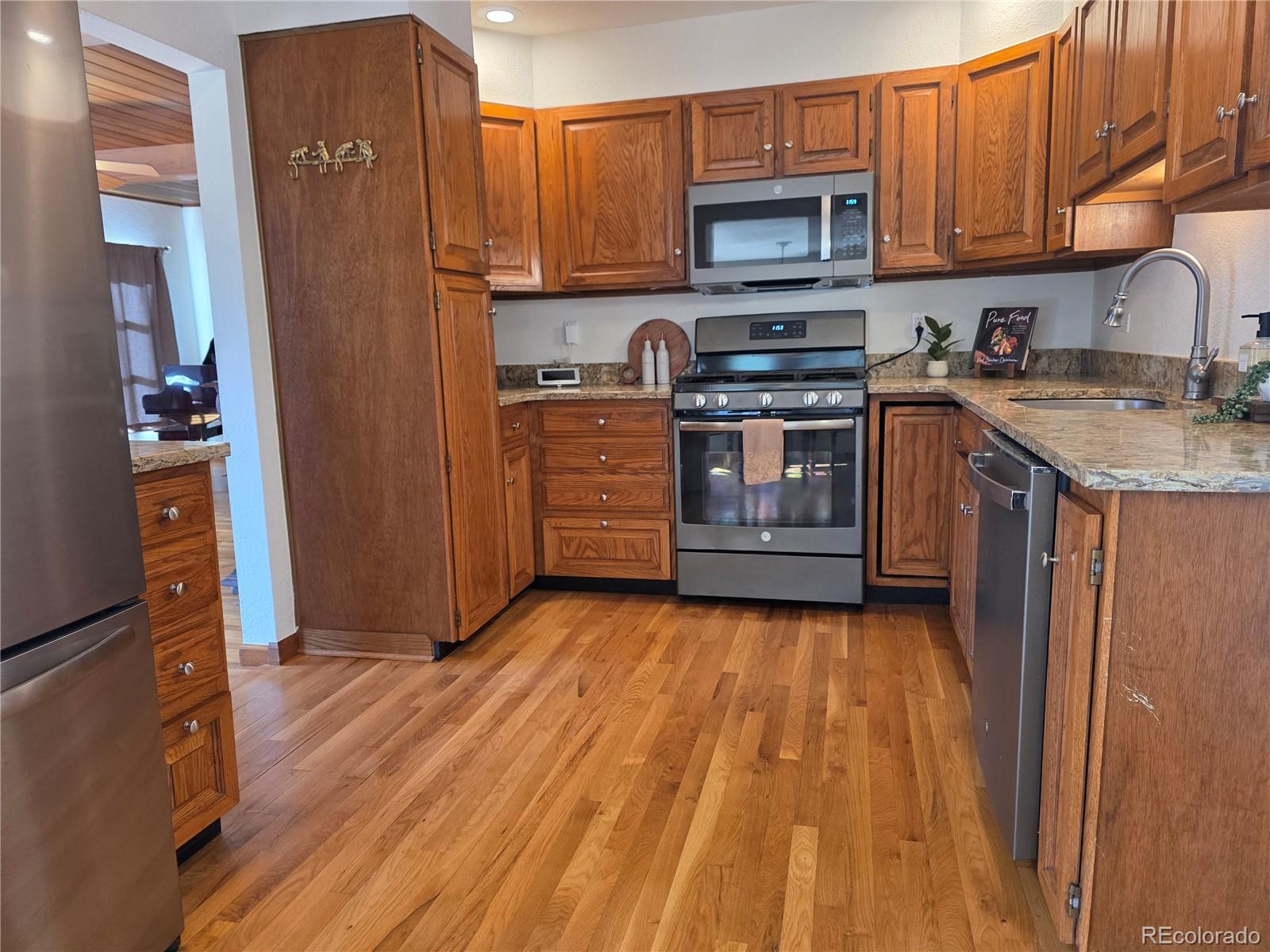 8830 South Blue Creek Road Evergreen, CO 80439 - Photo 18 of 39 a kitchen with a sink a microwave and cabinets