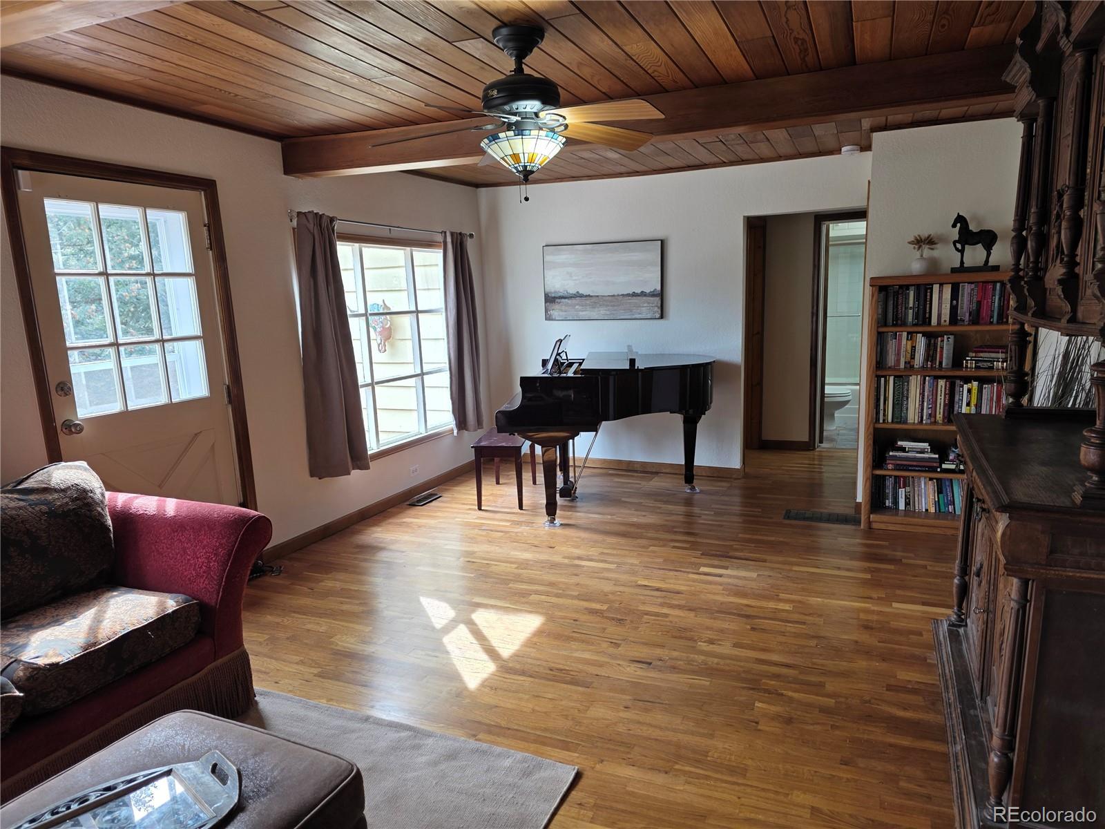 8830 South Blue Creek Road Evergreen, CO 80439 - Photo 20 of 39 a living room with furniture dining table wooden floor and a chandelier