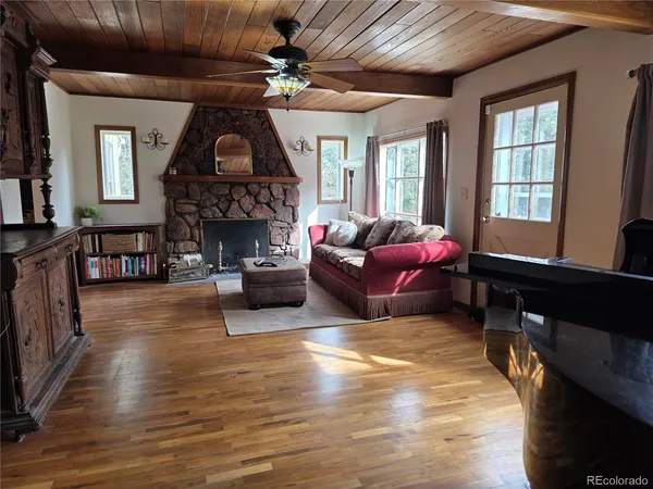 a living room with furniture a fireplace and a large window
