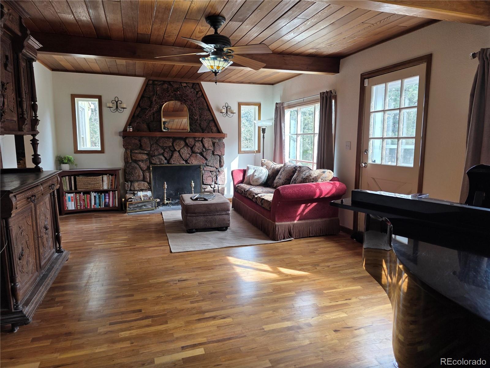 8830 South Blue Creek Road Evergreen, CO 80439 - Photo 21 of 39 a living room with furniture a fireplace and a flat screen tv