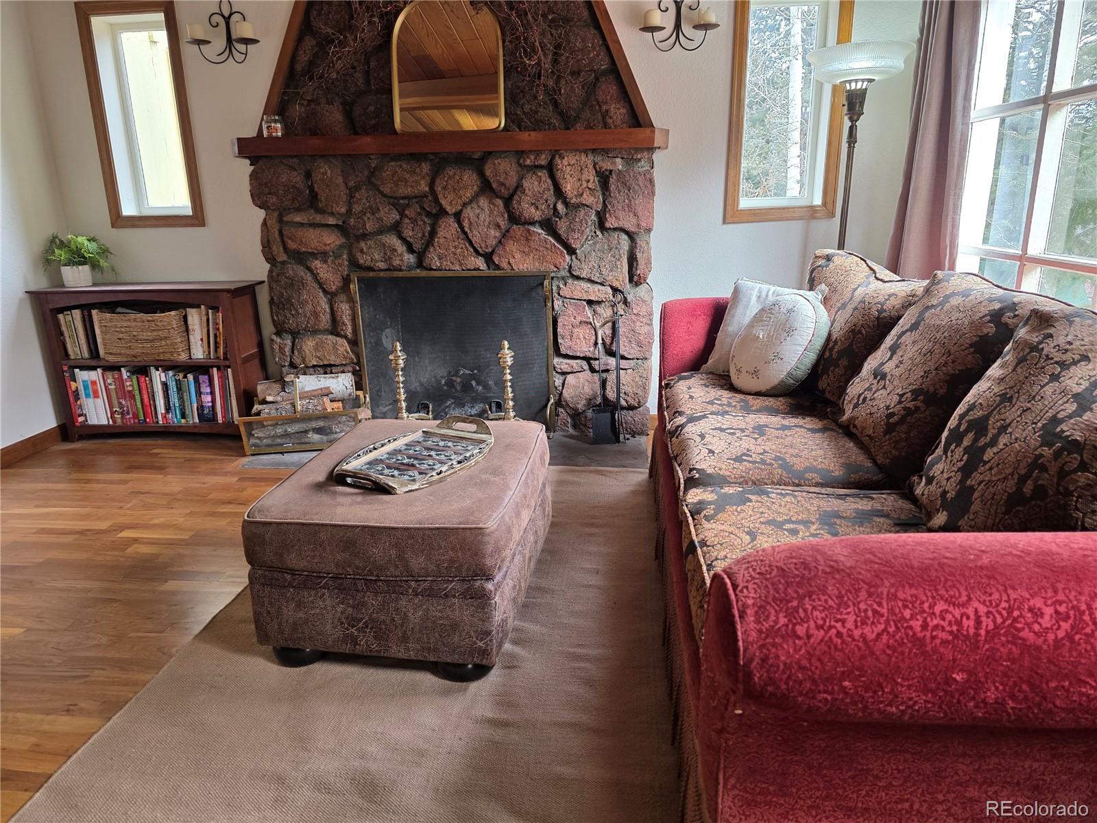 8830 South Blue Creek Road Evergreen, CO 80439 - Photo 22 of 39 a living room with furniture a fireplace and a large window
