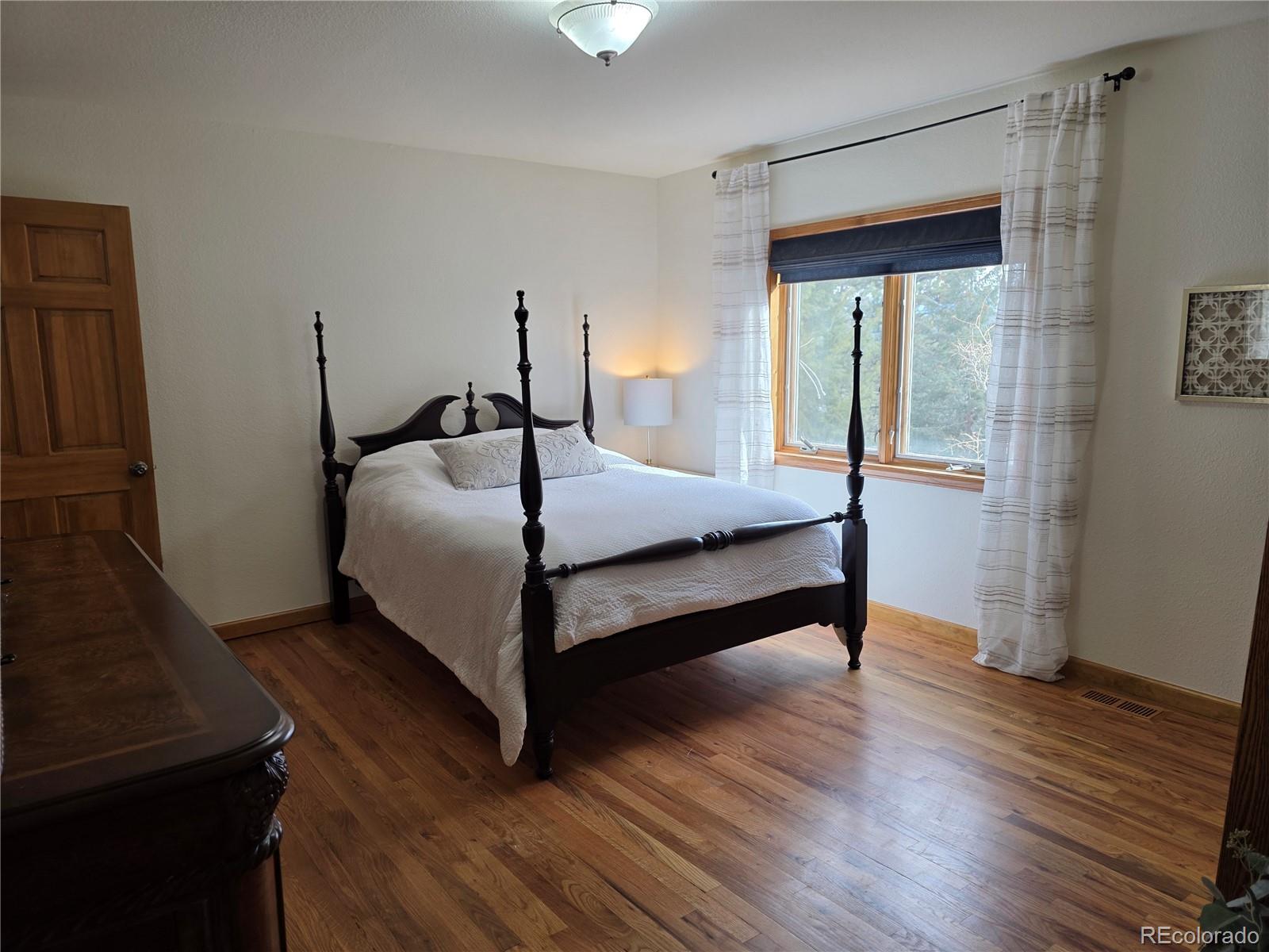 8830 South Blue Creek Road Evergreen, CO 80439 - Photo 25 of 39 a bedroom with a bed and a table