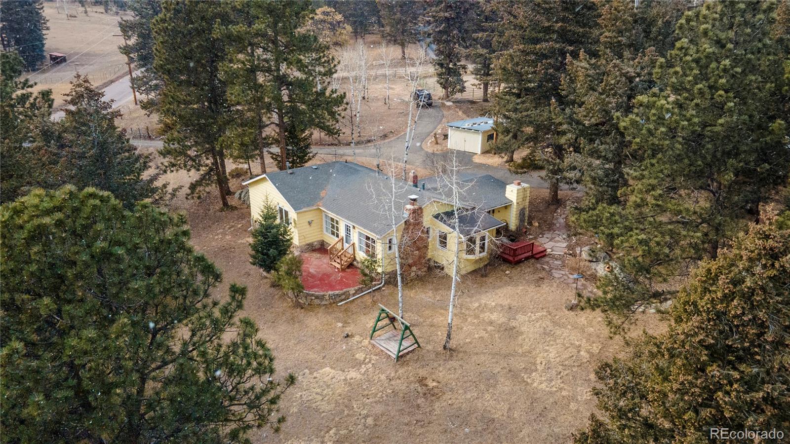 8830 South Blue Creek Road Evergreen, CO 80439 - Photo 3 of 39 a view of a backyard with wooden fence and a fire pit