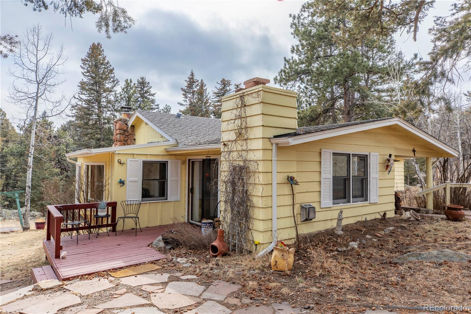 8830 South Blue Creek Road Evergreen, CO 80439 - Photo 8 of 39 a view of a house with backyard and sitting area