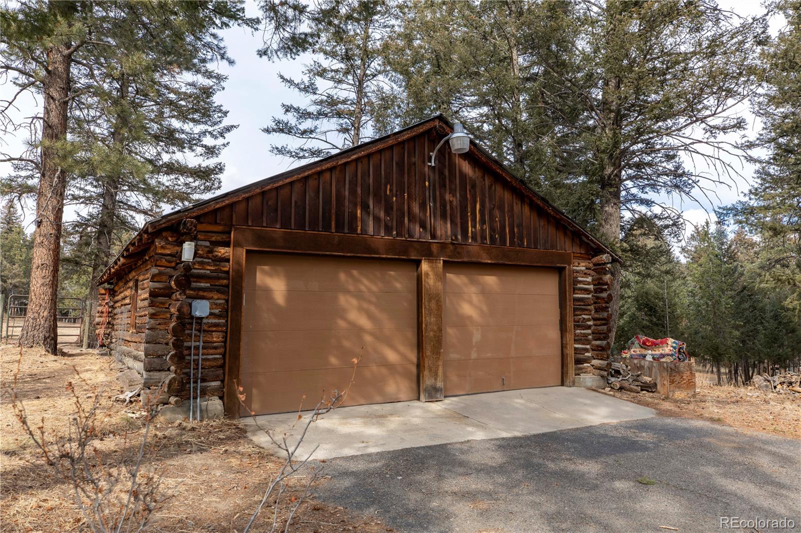 8830 South Blue Creek Road Evergreen, CO 80439 - Photo 10 of 39 a backyard of a house with table and chairs under an umbrella