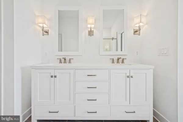 a bathroom with white cabinets and a sink