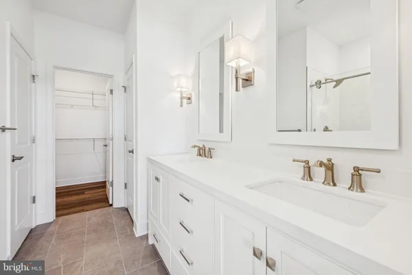 a bathroom with a double vanity sink a mirror and a shower