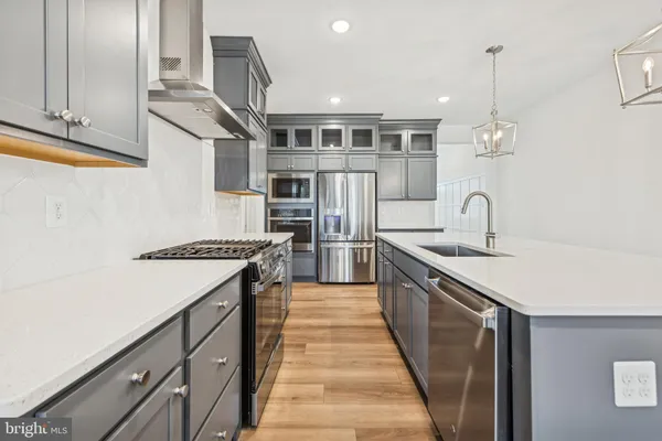 a kitchen with stainless steel appliances granite countertop a sink and a stove