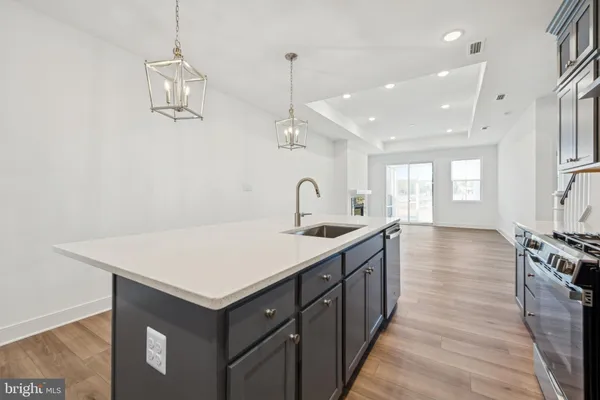 a kitchen with sink stove and refrigerator