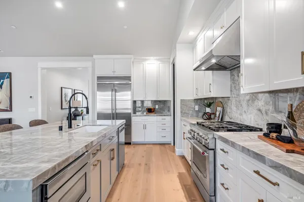 a kitchen with granite countertop a sink stainless steel appliances and cabinets