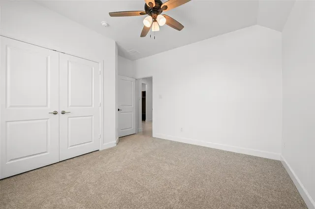 an empty room with a ceiling fan and a window