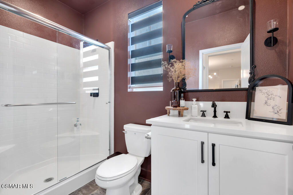 3028 Harrison Lane Simi Valley, CA 93065 - Photo 36 of 47 a bathroom with a granite countertop sink toilet a mirror a vanity and shower