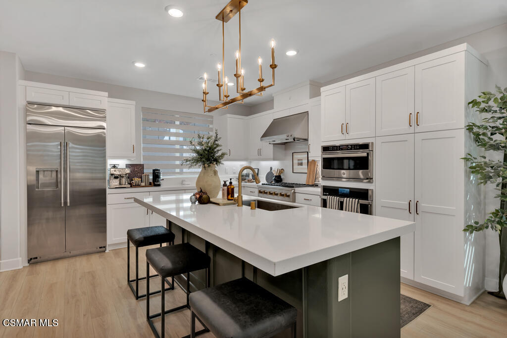 3028 Harrison Lane Simi Valley, CA 93065 - Photo 7 of 47 a kitchen with stainless steel appliances a table chairs and refrigerator