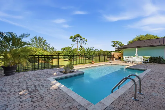 an open kitchen with stainless steel appliances kitchen island granite countertop a table chairs in it and wooden floors