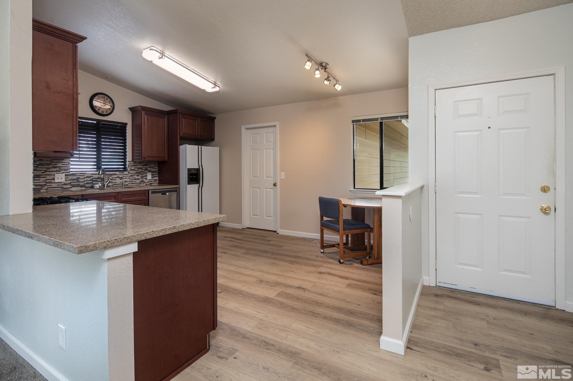 5335 Seville Court Reno, NV 89523 - Photo 5 of 31 an open kitchen with granite countertop a sink and a stove with wooden floor